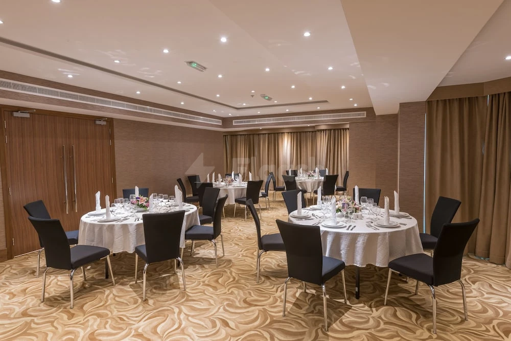 Banquet hall at Hawthorn Suites by Wyndham Abu Dhabi City Center, Abu Dhabi, with round tables set for