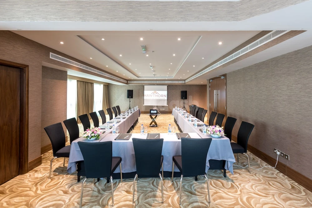 Conference room at Hawthorn Suites by Wyndham Abu Dhabi City Center, Abu Dhabi, with U-shaped tables and floral