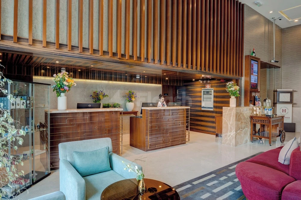 Lobby at Hawthorn Suites by Wyndham Abu Dhabi City Center, Abu Dhabi, featuring wooden slat ceiling and colorful