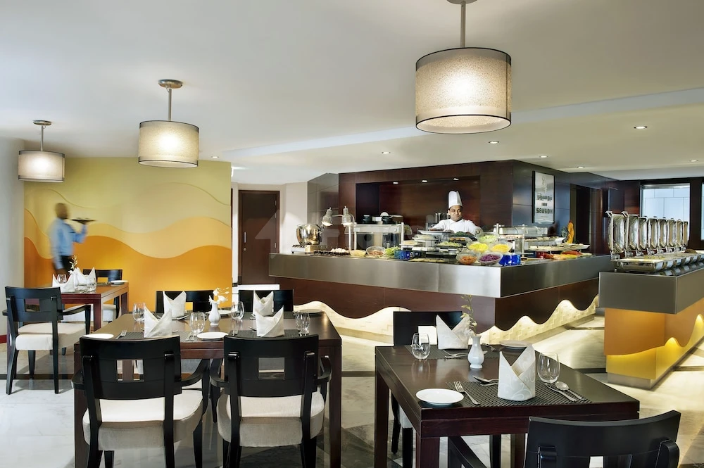 Dining area at City Seasons Towers Torch Tower, Dubai, featuring buffet station and warm yellow accent wall