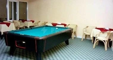 Pool table (with blue felt) in a, Holiday Beach Motel, Dibba, Fujairah, with checkered flooring and red-clothed tables