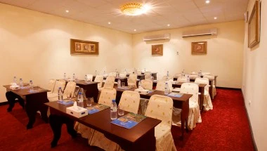 Conference room at Bin Majid Beach Resort, Ras Al Khaimah, with wooden tables and red carpeting