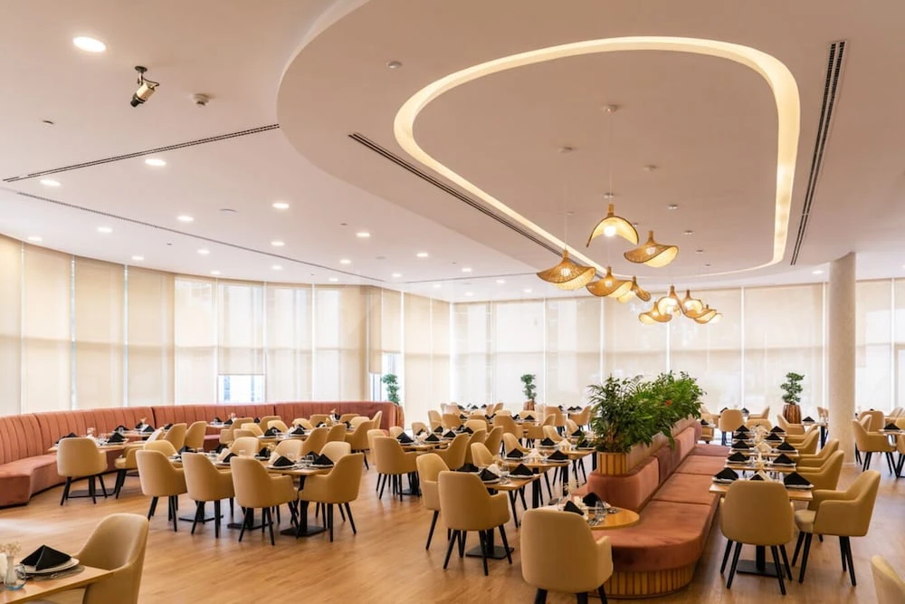 Dining area at eStay Hotel Dubai, Dubai, featuring warm lighting fixtures and terracotta upholstered seating
