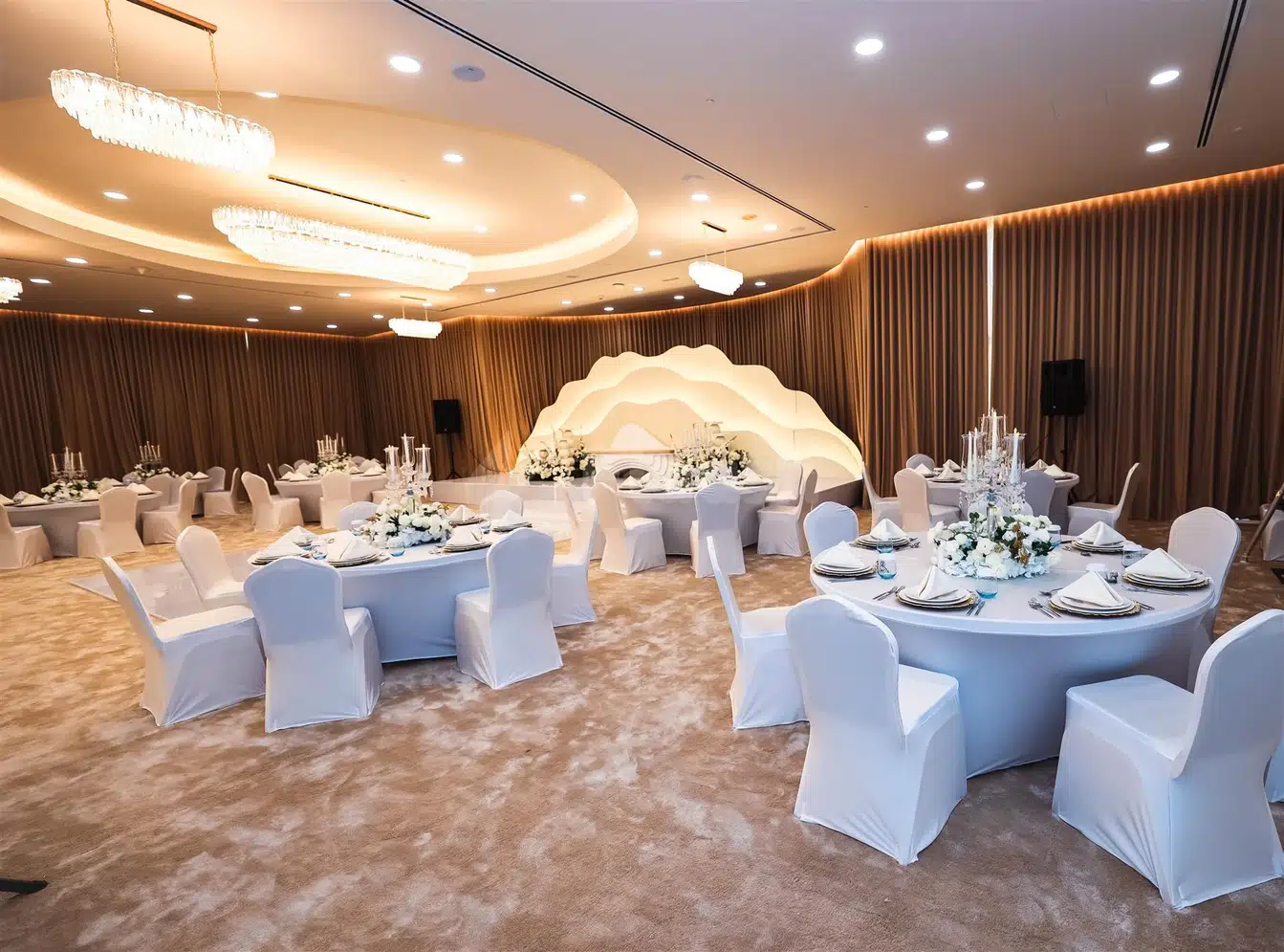 Elegant banquet space at eStay Hotel Dubai, Dubai, with white draped tables and chairs under modern chandeliers