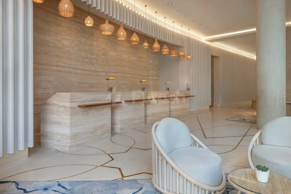 Lobby at Crowne Plaza Abu Dhabi - Yas Island, Abu Dhabi, with stone reception desks and woven pendant lights