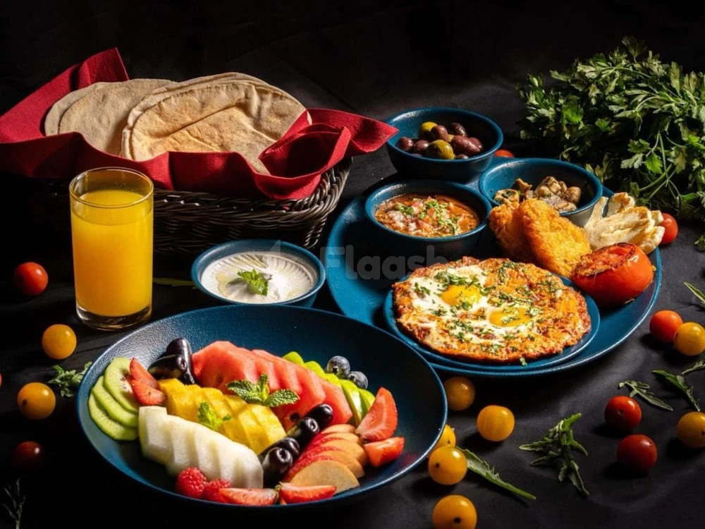 Breakfast spread at Majlis Grand Mercure Residence Abu Dhabi, featuring fresh fruit, eggs, and flatbread