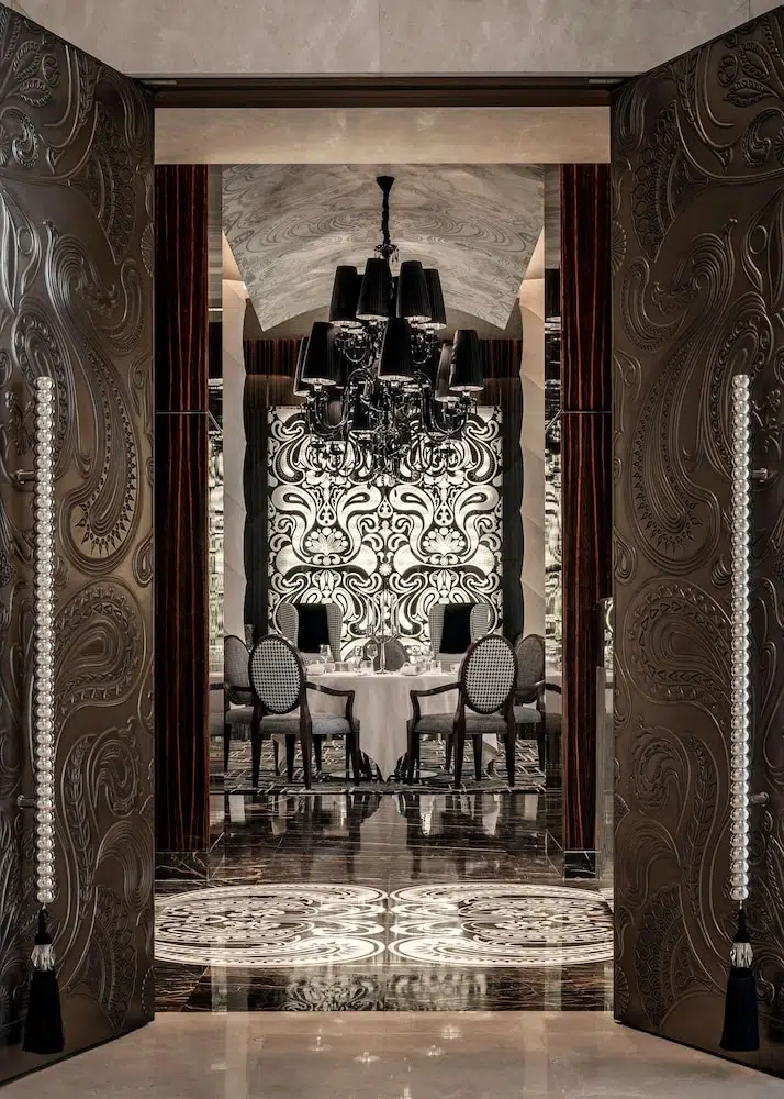 Luxury dining space at One&Only The Palm, Dubai, featuring ornate doors and a grand chandelier