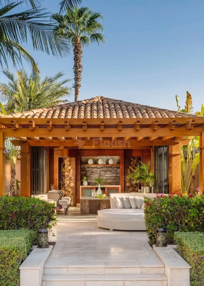Outdoor lounge at One&Only The Palm, Dubai, featuring a circular sofa and terracotta tiled roof surrounded by