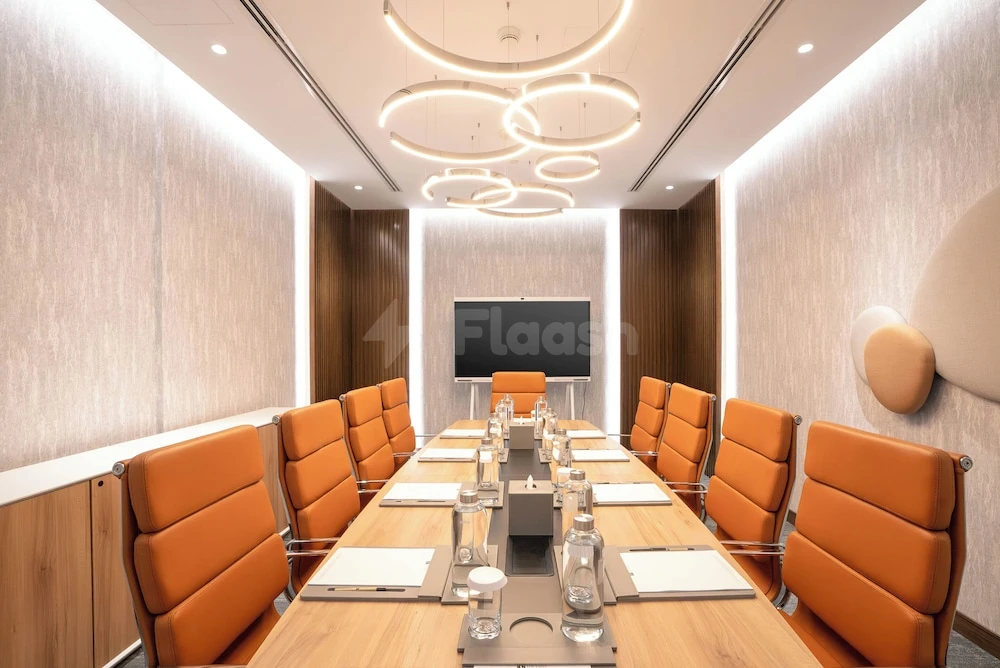 Boardroom at The First Collection Dubai Business Bay, Dubai, featuring orange leather chairs and circular pendant lights