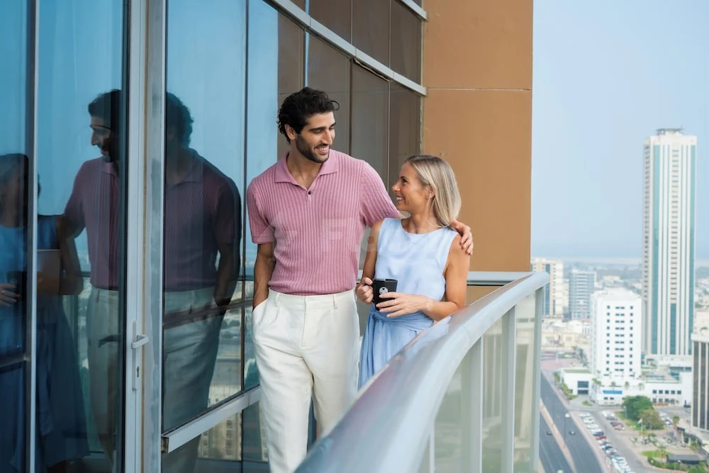 Balcony at Nour Arjaan by Rotana, Fujairah, with glass railings and city views