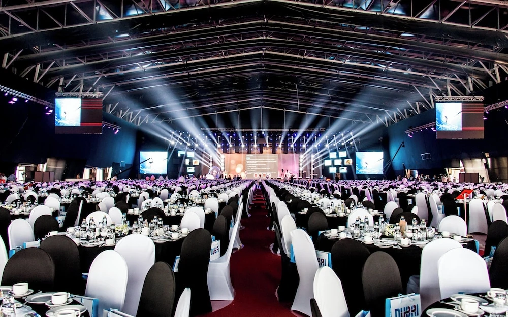 Banquet hall at InterContinental Dubai Festival City, Dubai, with rows of tables under stage lights and large screens