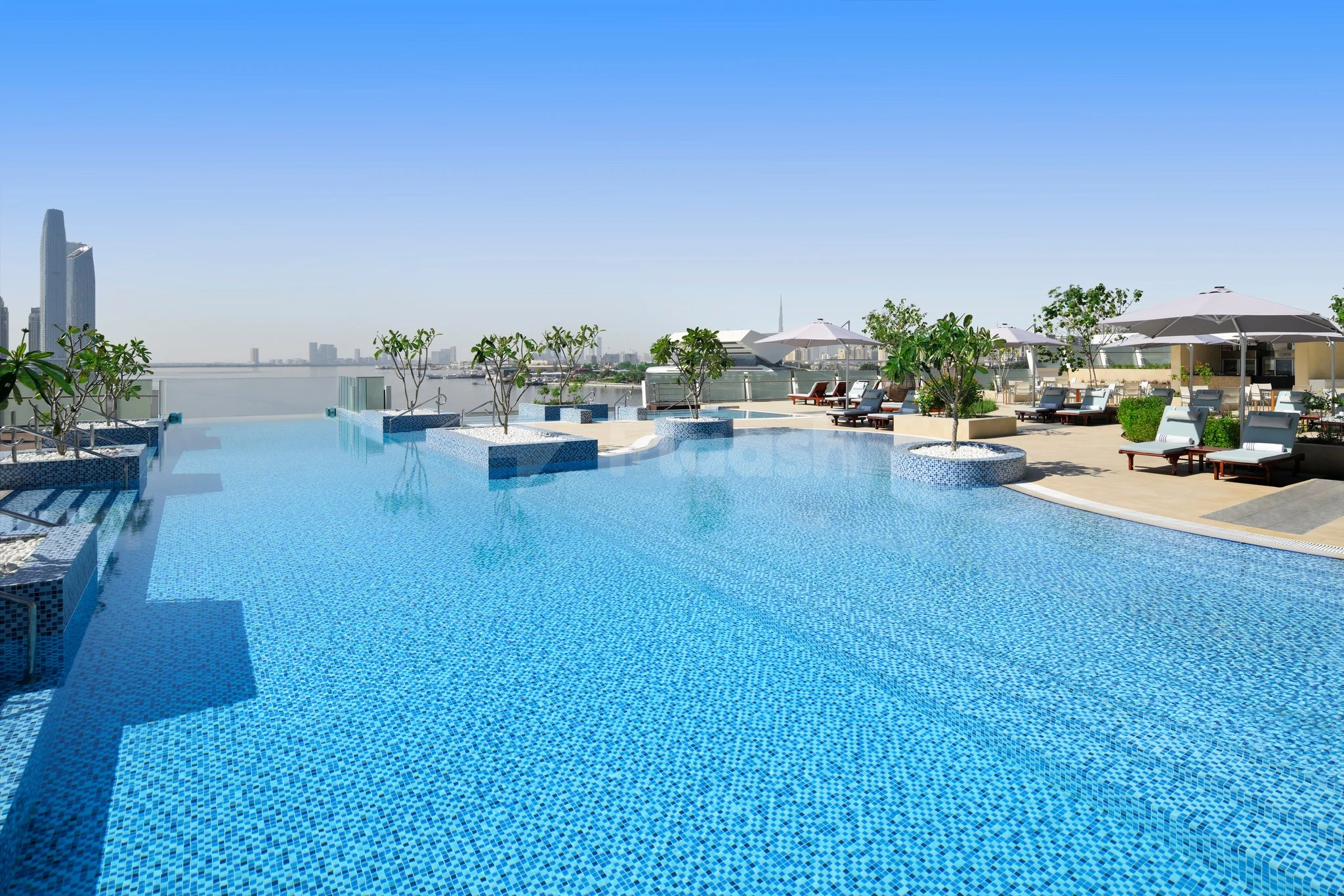 Rooftop infinity pool at Intercontinental Dubai Festival City, Dubai, with mosaic tiles and city skyline view