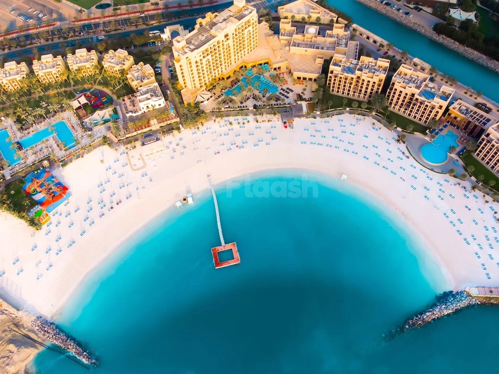 Curved beach at DoubleTree by Hilton Resort & Spa Marjan Island, Ras Al Khaimah, lined with lounge chairs
