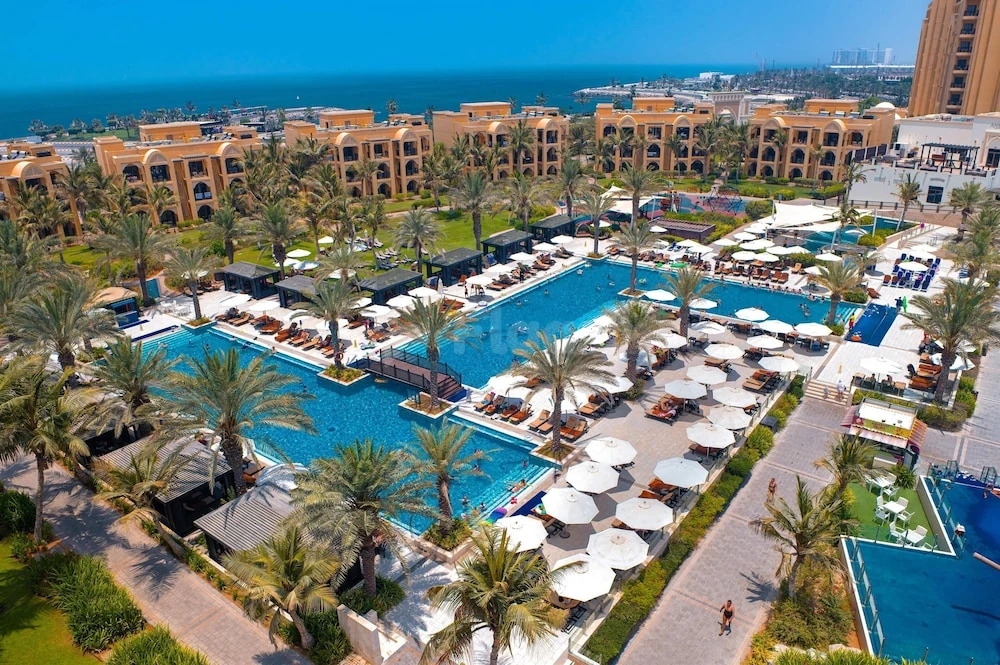 Lush poolside space at DoubleTree by Hilton Resort & Spa Marjan Island, Ras Al Khaimah, featuring palm trees