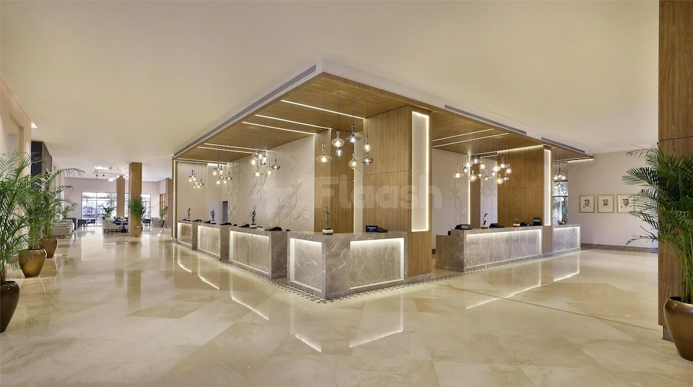 Marble reception area at DoubleTree by Hilton Resort & Spa Marjan Island, Ras Al Khaimah, featuring illuminated wooden panels