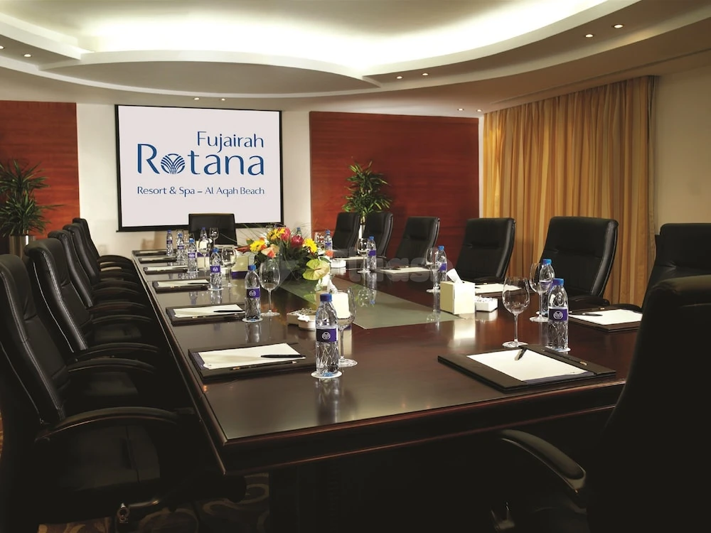 Conference room at Fujairah Rotana Resort & Spa – Al Aqah Beach, Fujaira, with branded screen and floral centerpiece