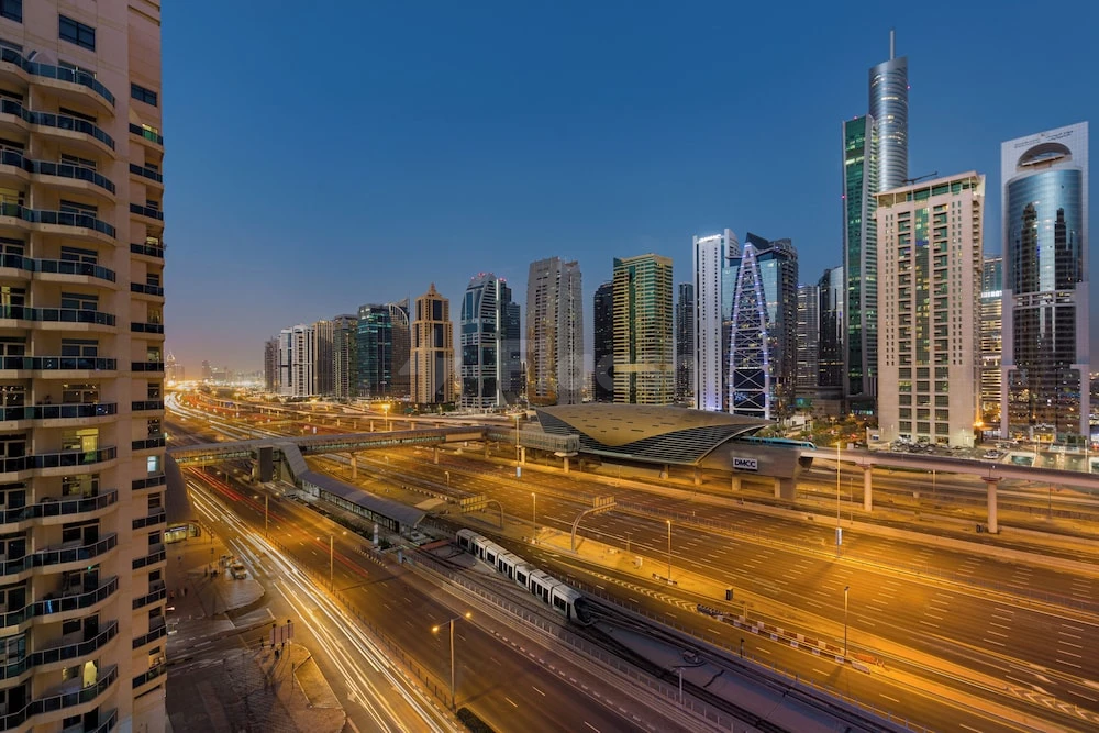 Rooftop terrace at Millennium Place Marina, Dubai, overlooking illuminated highways and modern towers at dusk