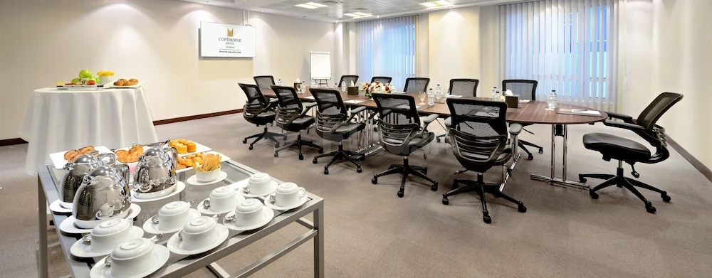 Conference room at Copthorne Hotel Sharjah, Sharjah, with black mesh chairs and a buffet table