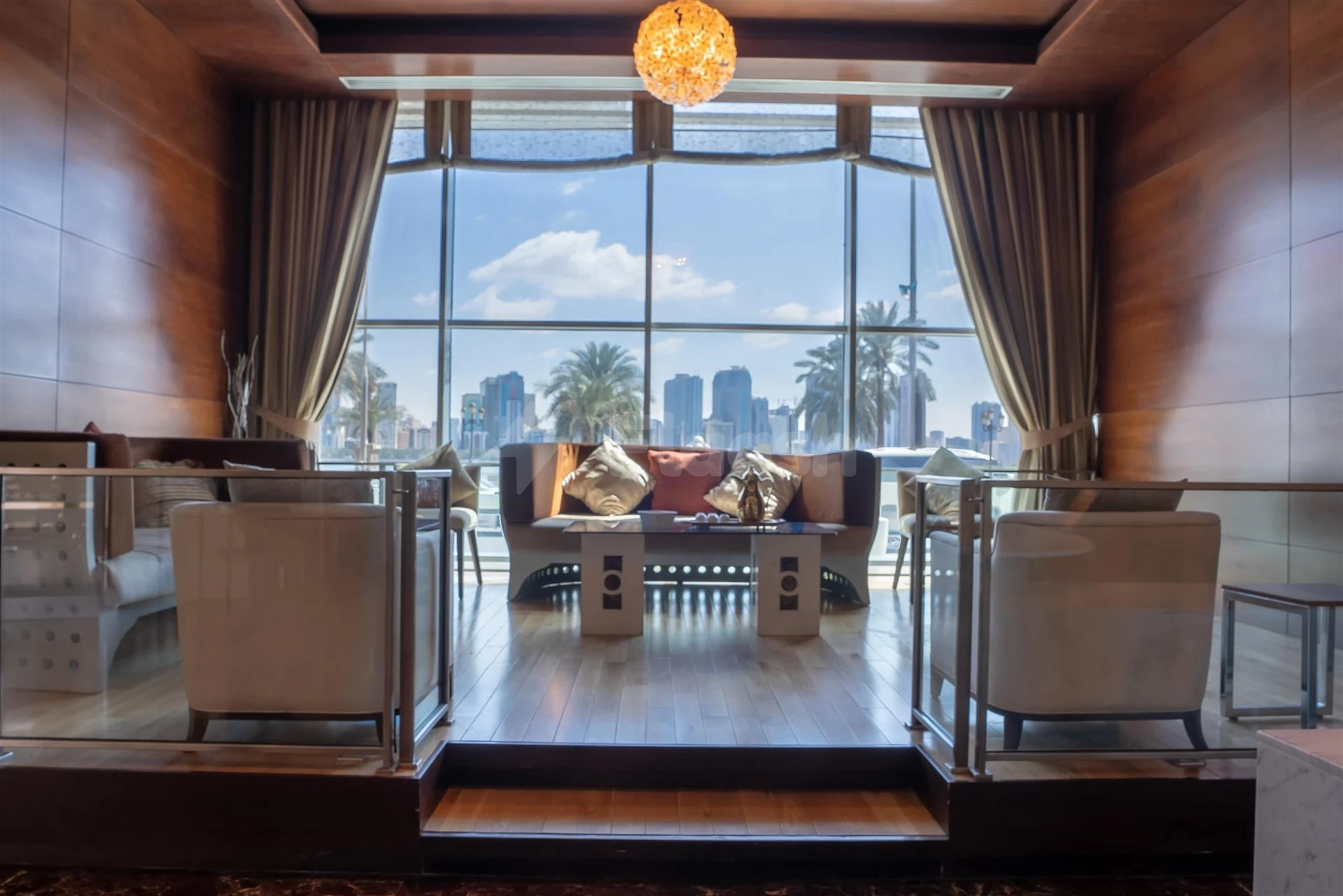 Lobby lounge at Copthorne Hotel Sharjah, Sharjah, with wooden paneling and city view through large glass windows